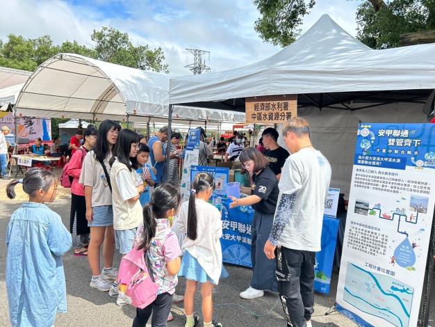 好幾位小朋友在攤位前好奇地觀看「聯通你和我」互動遊戲