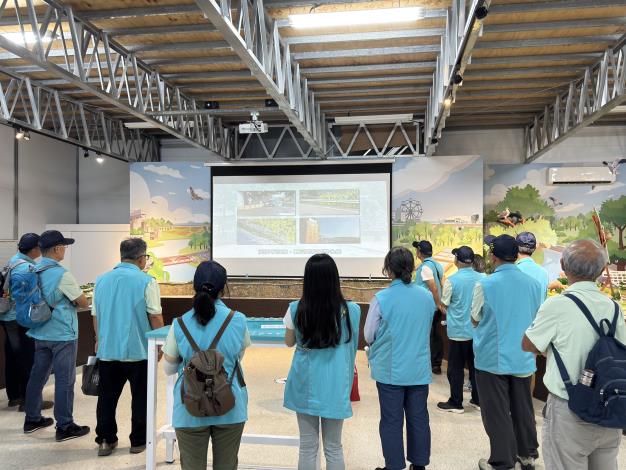 志工們於展示中心內觀賞工程介紹影片