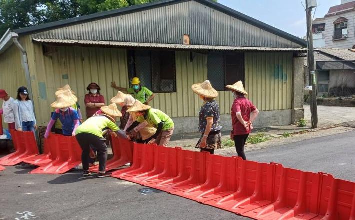 柳營八翁社區防汛整備演練，民眾設防水擋板。